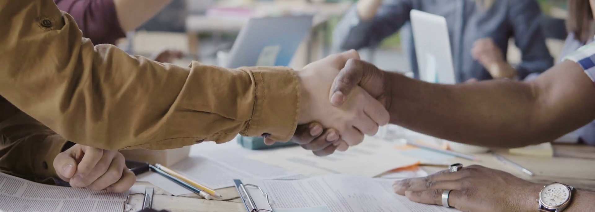 videoblocks-two-partners-african-and-caucasian-businessmen-shake-hands-group-of-people-clapping-on-a-background-at-modern-office_r6ykvvdyb_thumbnail-full03